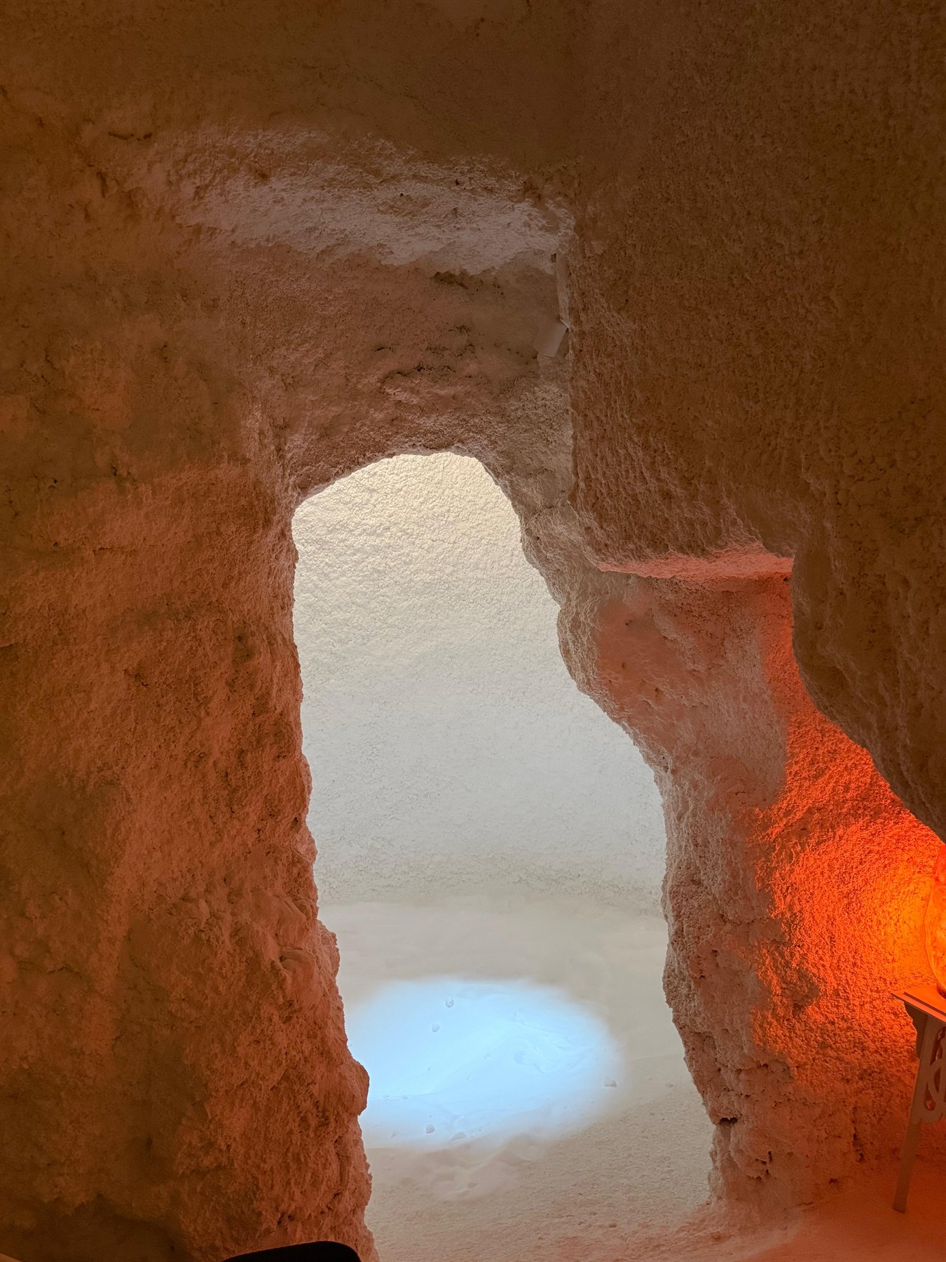 Entrada excavada de la cueva de sal, iluminada en tonos cálidos