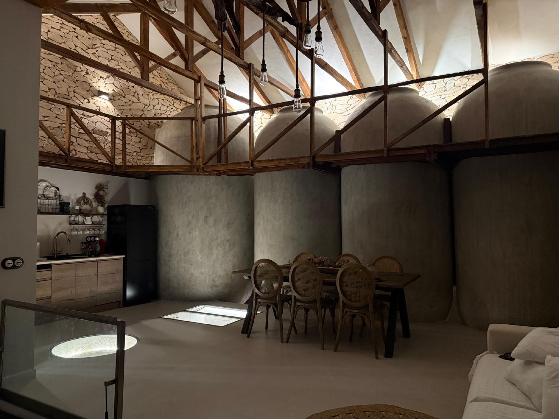 Antigua bodega restaurada con tinajas, vigas de madera y comedor